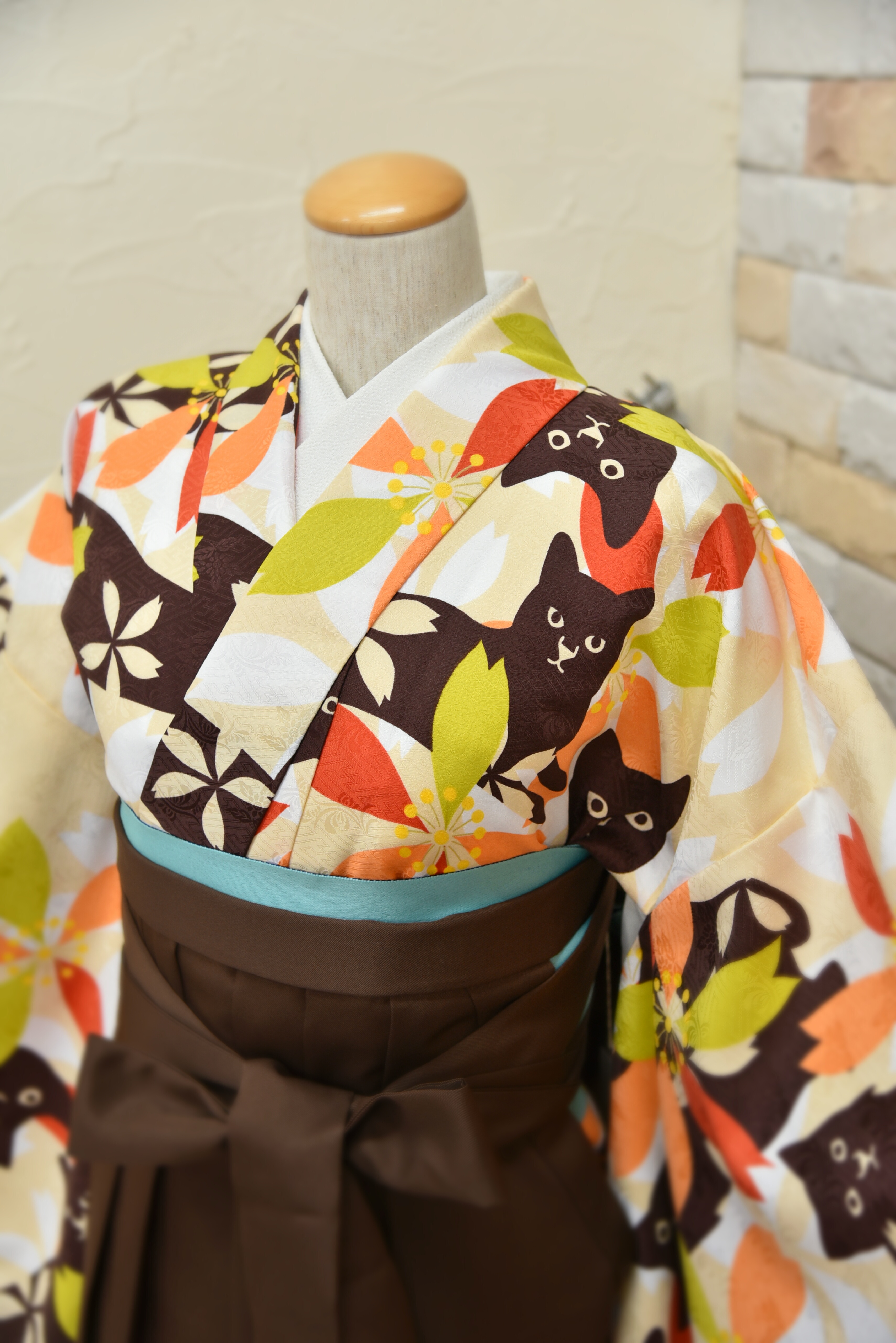 ベージュに桜と猫の卒業式用着物コーデのアップ。袴は焦げ茶