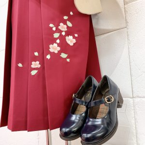 小豆色～赤色の袴の桜刺繍部分アップと紺色の靴の組み合わせ写真