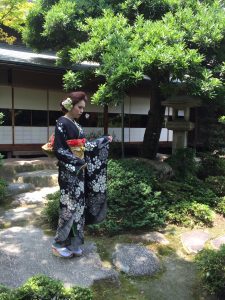日本庭園で佇む黒の総絞り振袖の女性