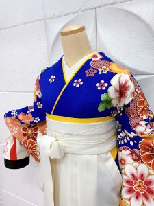 青に橙で花柄の絵羽模様kimonoに白hakamaを着付けたトルソー写真