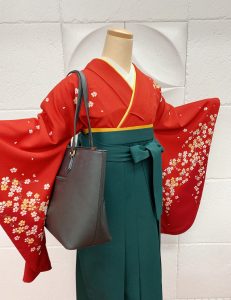 赤地に白桜柄の卒業式kimonと深緑の袴。鞄は黒