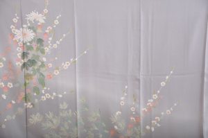 水色グレーに菊と梅が描かれた加賀友禅の訪問着を広げた写真