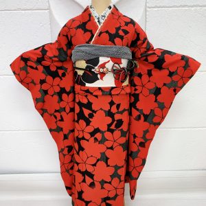 黒地に赤の桜柄の振袖。帯や半襟、帯揚げ帯締め重ね衿も全て赤白黒で統一されている