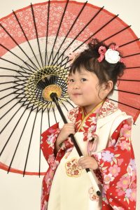 七五三で3歳女児が着るshikibu romanブランドの着物レンタルフルセットの着用写真。ひな祭りの雛のような袖や重ね衿がかわいい。衿も桜と梅柄なこだわりのデザイン