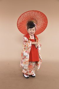 大正ロマンを感じるアンティークレトロな菊と扇面雲の多彩な古典の小紋風kimonoを着こなしたキュートな表情の七五三3歳の女児写真