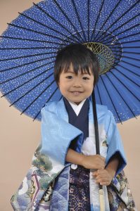 爽やかな水色の羽織に青のきものを着付けてもらい良い表情を浮かべる三歳の男の子。袴は金彩入りのかっこいいのを選んでいる。（実際に七五三着物レンタルフルセットを注文したお客様）
