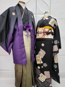 黒から紫ぼかしの紋付きに白から黒ぼかしに金の縞袴、振袖はブラックに薄紫の色紙柄の古典