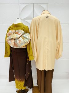茶色とマスタードのぼかし地にカラシの鈴蘭が描かれた成人式向け女の子衣装とﾍﾞｰｼﾞｭに茶袴のブラウンコーデの後ろ姿