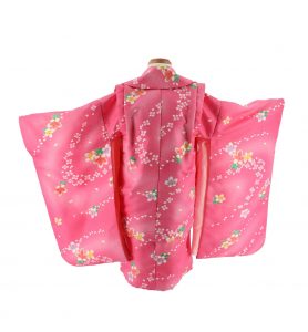 濃いピンク地に小さい花柄が流水文様状に描かれた七五三の3歳で女児が着用する着物レンタル配送フルセット。シンプルかつレトロなデザインは幅広い 乙 女に合う（後ろ姿）