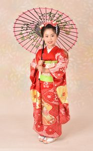 スタッフの家族からキッズモデルを申し受ける事になったキモノガール。7歳相応のアンティークな小 振袖フルセットを着付けてもらい日本 髪風に結われている。スタジオ環境で撮影された