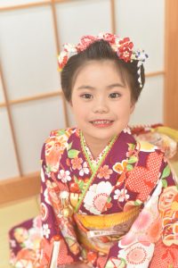 アンティーク寄りな意匠の七才キッズが対象の四つ身を着付てもらった女の子の記念日フォト。重ね衿や半襟がよく見える。ヘアスタイルも京都の和服体験のようにスタイリングしている