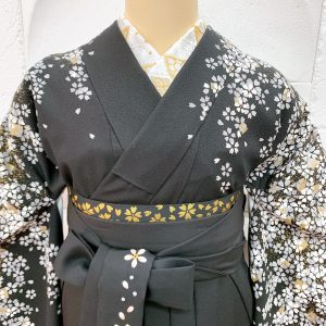黒地に金銀の小桜がぎっしり描かれた卒業式着物に裾と紐に桜の刺繍が入った黒袴を着付けられたトルソー写真。シンプルかつ綺麗な組み合わせ。半衿や帯の模様がより確認出来る衿元写真
