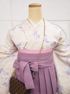 クリームにピンクと紫の花と小鳥柄小紋と薄紫色の袴の組み合わせ。卒業式袴でも淡色コーデらしいおしゃれさと可愛らしさがある。襟元のアップ