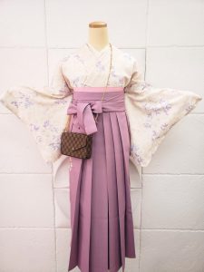 クリームにピンクと紫の花と小鳥柄小紋と薄紫色の袴の組み合わせ。卒業式袴でも淡色コーデらしいおしゃれさと女性らしさがある