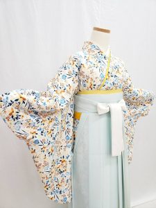 白地に青、水色、ベージュ、オレンジの小花柄小紋きものに、淡い水色の袴の組み合わせ。卒業式袴でおすすめの淡色コーデ