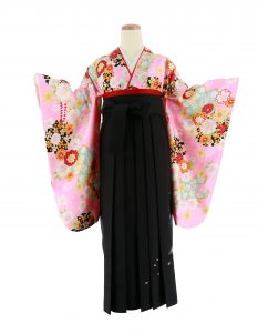 小学生 卒業式袴レンタル [ポップ]ピンク・黄水色赤黒桜菊の着用画像。ピンク地に黒と水色の桜、オレンジと赤色の小ぶりな菊を描いた小振袖です